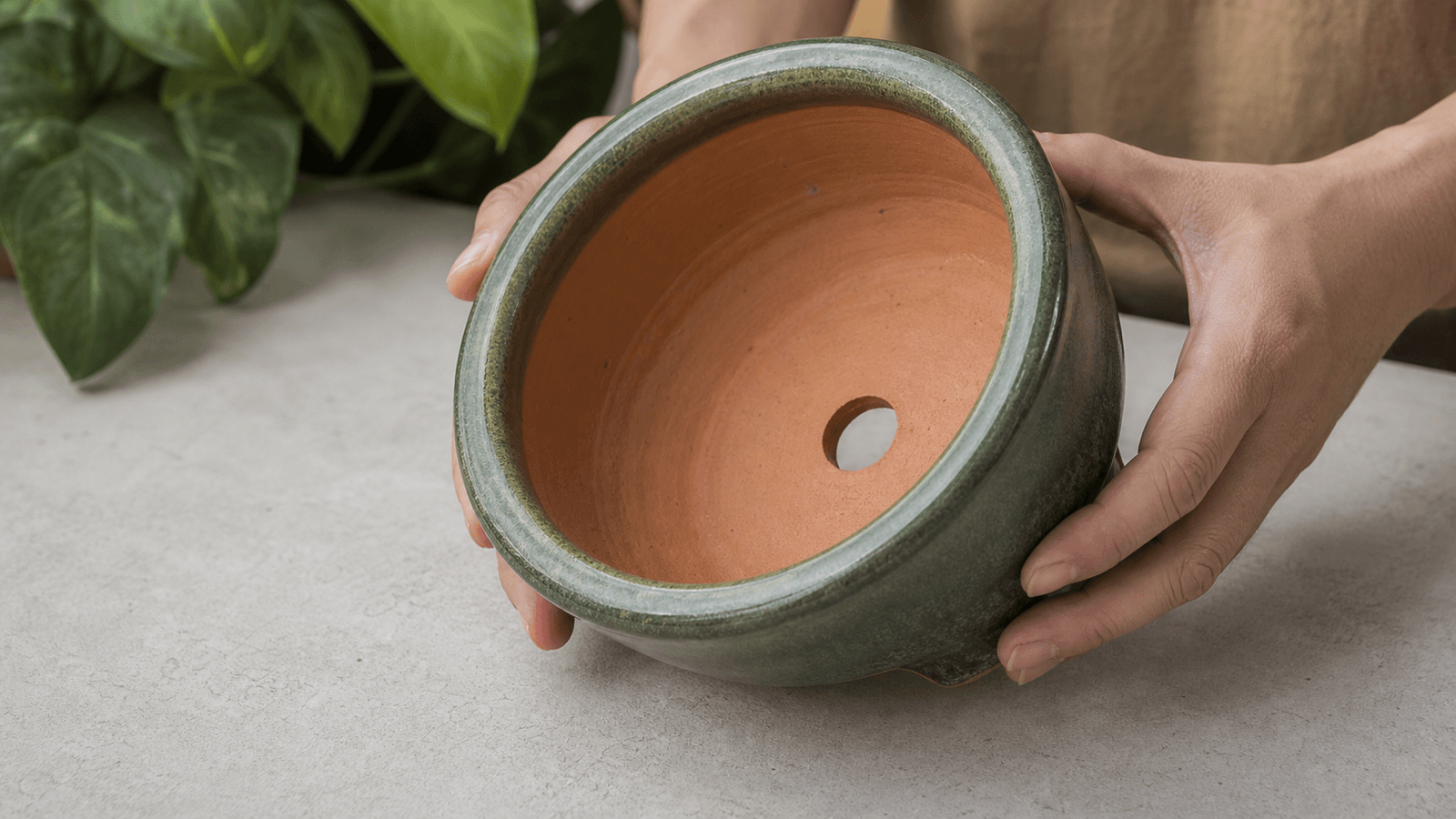 Cận cảnh đáy chậu gốm có lỗ thoát nước và lớp men bên ngoài